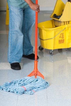 J&J Commercial Cleaning LLC janitor in Olmos Park, TX mopping floor.